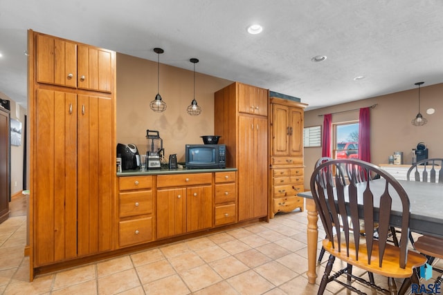 29783 Frog Creek Rd, Centerville, SD 57014 - kitchen with lofted ceiling, light tile patterned floors, hanging light fixtures, black microwave, and brown cabinetry