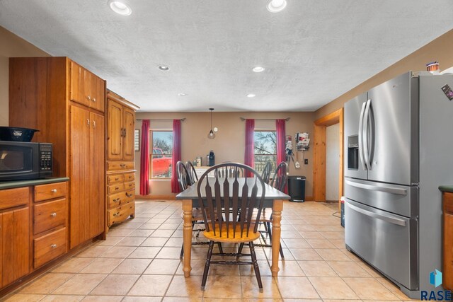 29783 Frog Creek Rd, Centerville, SD 57014 - kitchen featuring stainless steel fridge with ice dispenser, light tile patterned floors, black microwave, and brown cabinets
