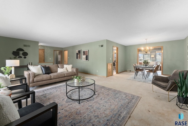 living area featuring baseboards, visible vents, an inviting chandelier, and light carpet