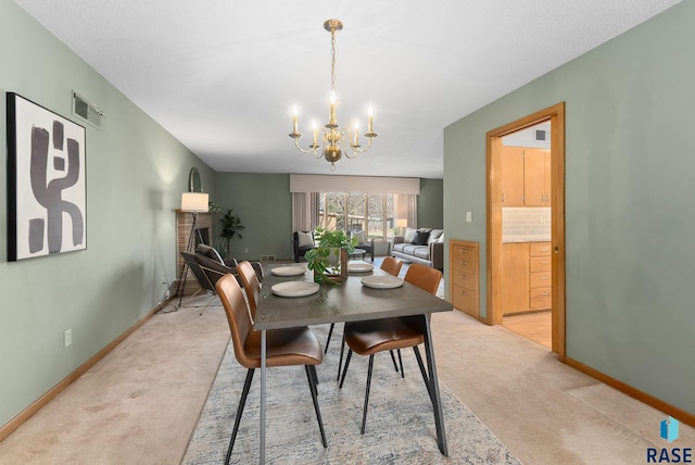 dining area featuring light carpet, baseboards, and a chandelier