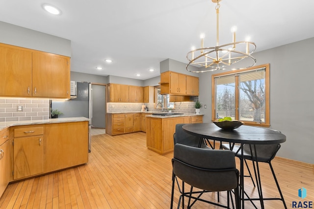 kitchen featuring light countertops, light wood-style floors, and a chandelier