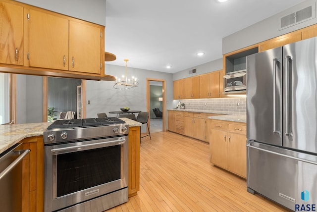 kitchen with decorative backsplash, light wood-style flooring, visible vents, appliances with stainless steel finishes, and an inviting chandelier