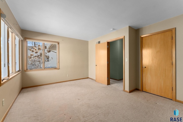 unfurnished bedroom featuring light colored carpet and baseboards