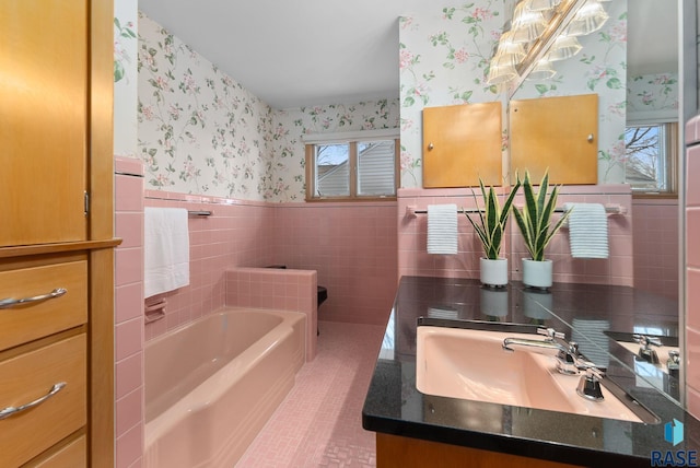 full bathroom with tile walls, wallpapered walls, tile patterned floors, a garden tub, and wainscoting