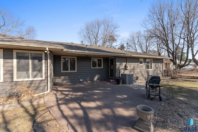 back of property with central AC unit and a patio