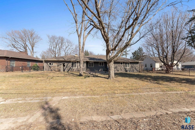 back of property featuring fence and a lawn