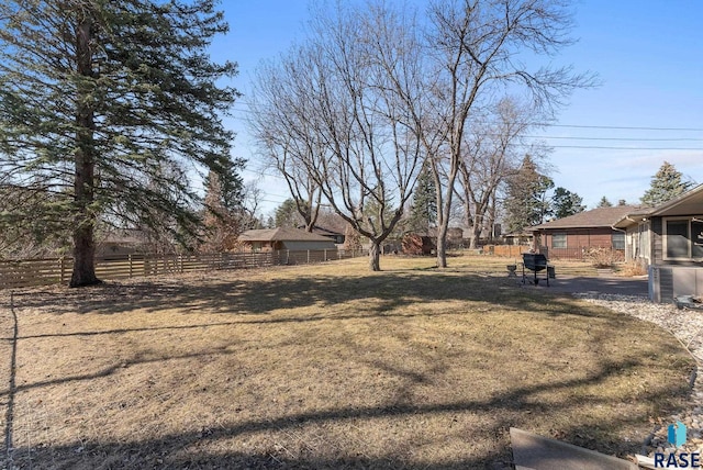 view of yard featuring central AC and fence