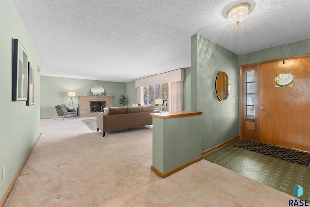 carpeted entryway with a textured ceiling, baseboards, and a brick fireplace
