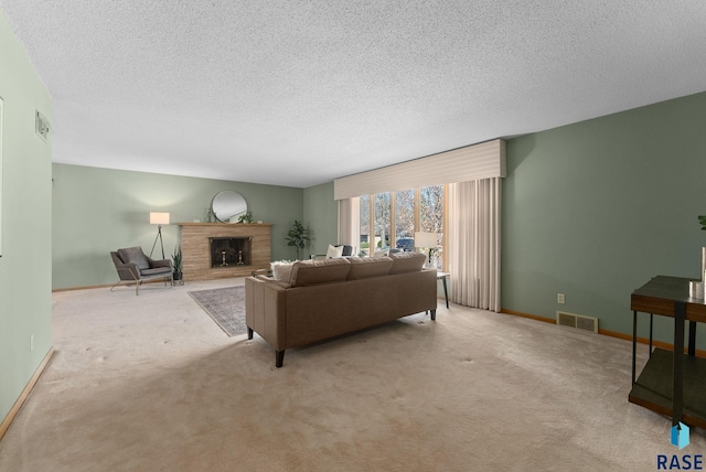 living area with carpet flooring, a fireplace, a textured ceiling, baseboards, and visible vents