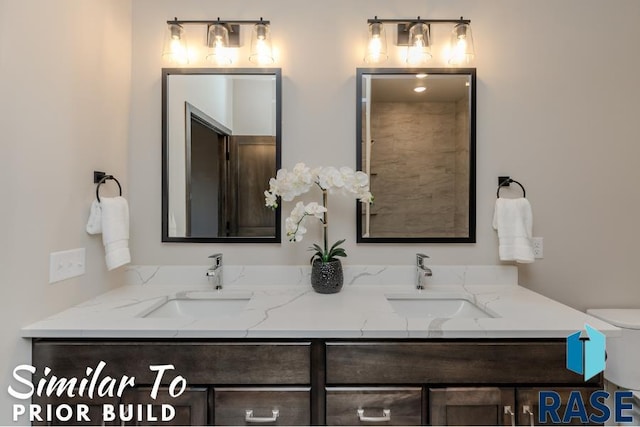 bathroom with double vanity, toilet, and a sink
