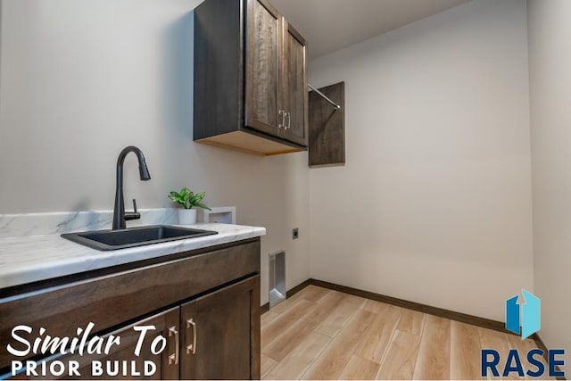 laundry room featuring hookup for an electric dryer, light wood-type flooring, hookup for a washing machine, a sink, and cabinet space