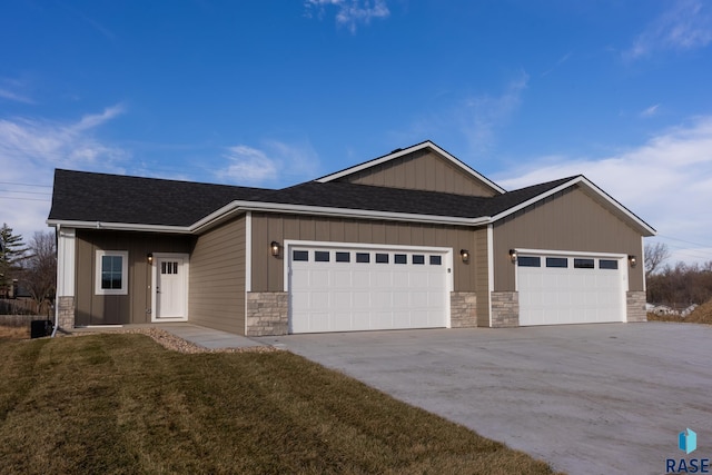 single story home with stone siding, an attached garage, a front lawn, driveway, and a shingled roof