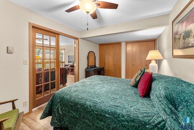 bedroom featuring light wood finished floors, two closets, and ceiling fan