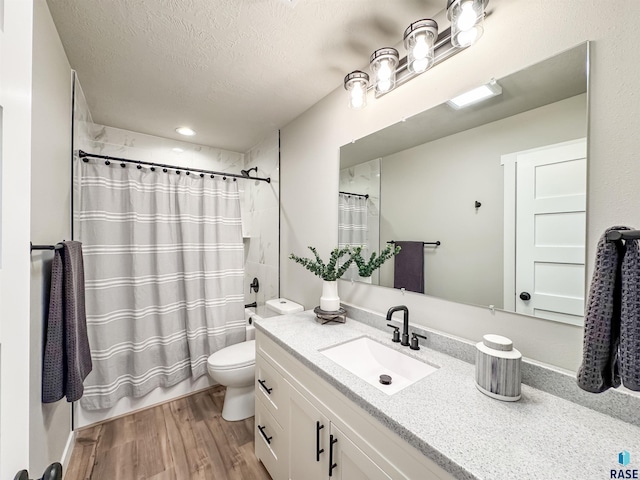 bathroom featuring a textured ceiling, wood finished floors, toilet, vanity, and shower / tub combo
