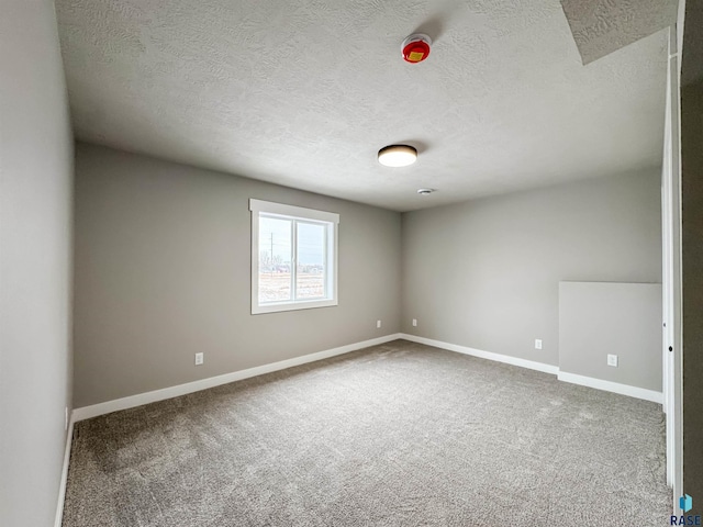 unfurnished room featuring baseboards, carpet floors, and a textured ceiling