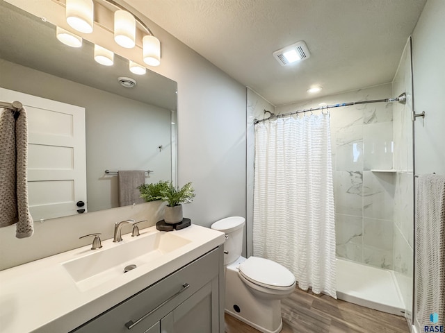 full bath with toilet, vanity, a shower with curtain, wood finished floors, and visible vents