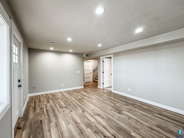 basement featuring visible vents, baseboards, stairs, wood finished floors, and recessed lighting