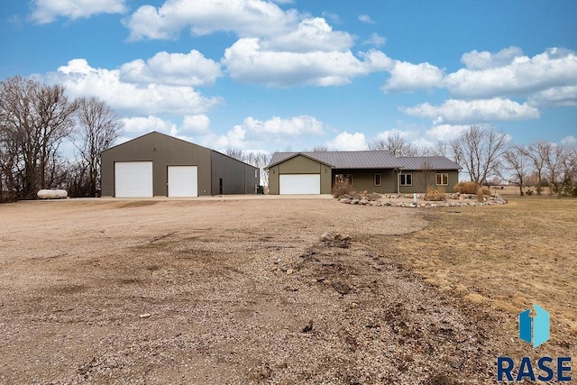 exterior space with a detached garage and metal roof