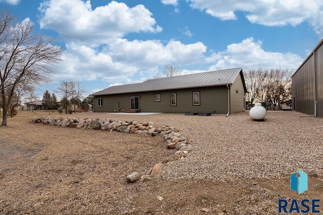 back of property featuring a patio area and metal roof