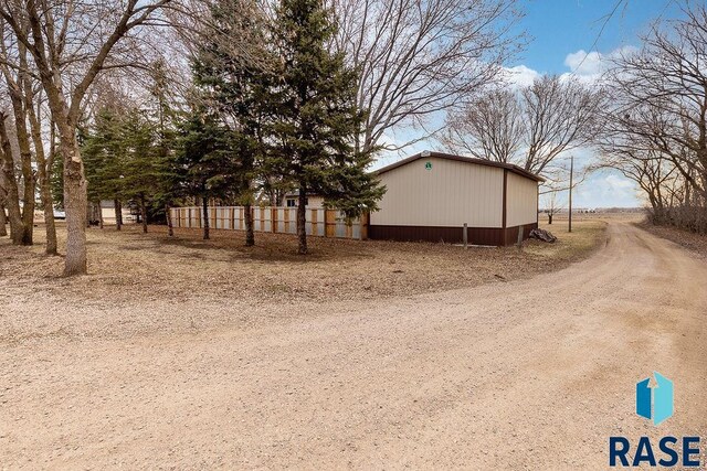 view of side of property with an outdoor structure, an outbuilding, and fence