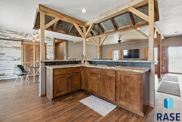 kitchen featuring dark wood-style floors, stainless steel gas stovetop, a wealth of natural light, and open floor plan