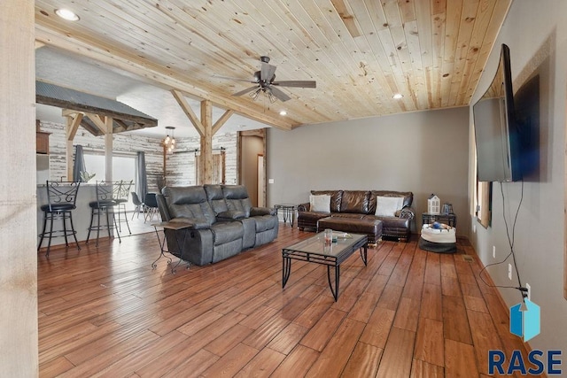 living area featuring beamed ceiling, ceiling fan, wood finished floors, recessed lighting, and wooden ceiling