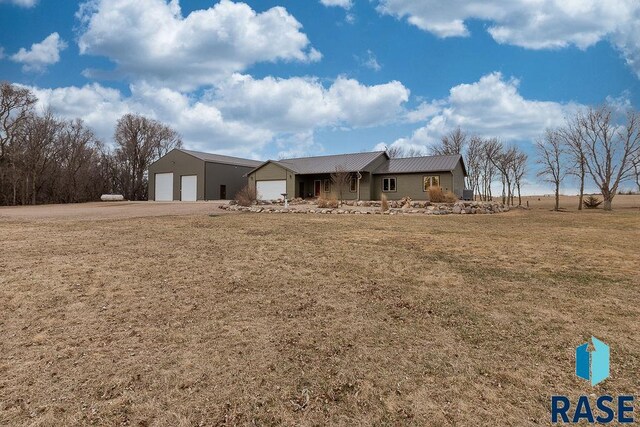 ranch-style home featuring metal roof and a front yard