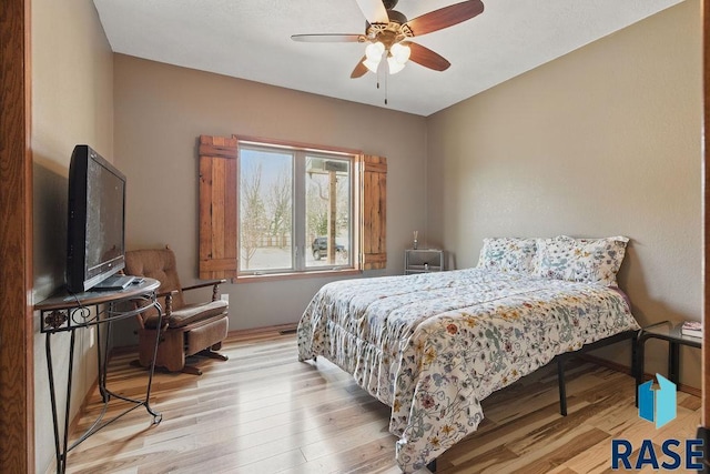bedroom featuring baseboards, ceiling fan, and wood finished floors