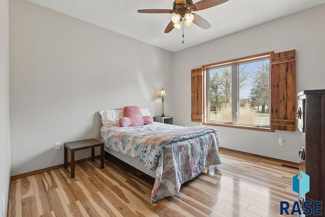 bedroom featuring light wood-style flooring, baseboards, and ceiling fan