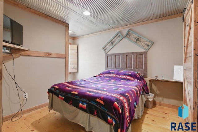 bedroom featuring baseboards and wood-type flooring