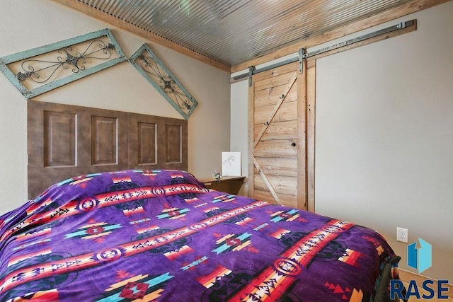 unfurnished bedroom with wood ceiling and a barn door