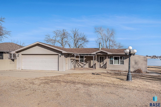 ranch-style house with a shingled roof, an attached garage, and concrete driveway