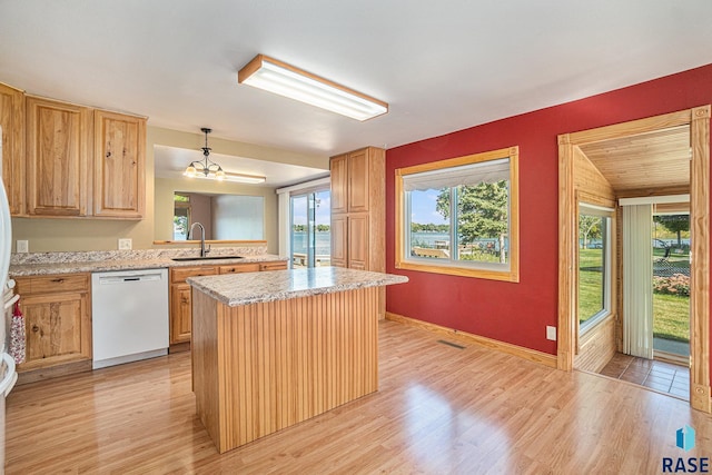 kitchen with light wood-style flooring, a sink, a kitchen island, and dishwasher