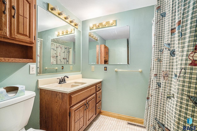 bathroom featuring visible vents, baseboards, toilet, vanity, and tile patterned flooring