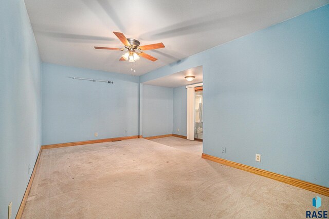 carpeted spare room with baseboards and a ceiling fan