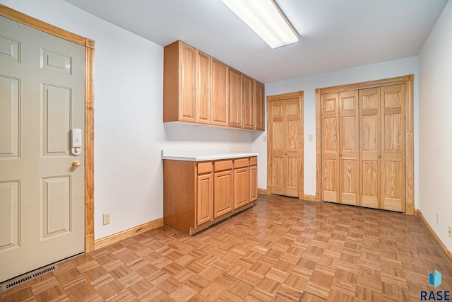 kitchen with light countertops, baseboards, and visible vents