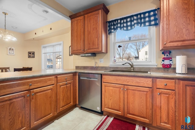 kitchen with stainless steel dishwasher, a sink, light tile patterned flooring, brown cabinetry, and decorative light fixtures