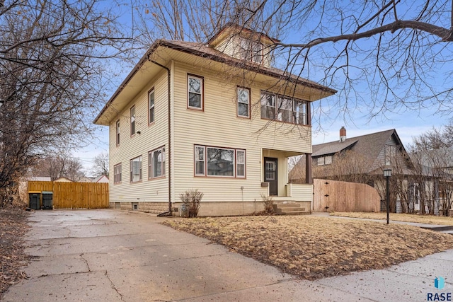 american foursquare style home with fence