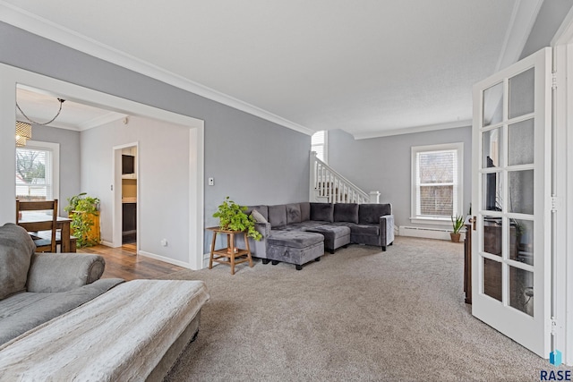 living room with a healthy amount of sunlight, stairs, a baseboard heating unit, and ornamental molding