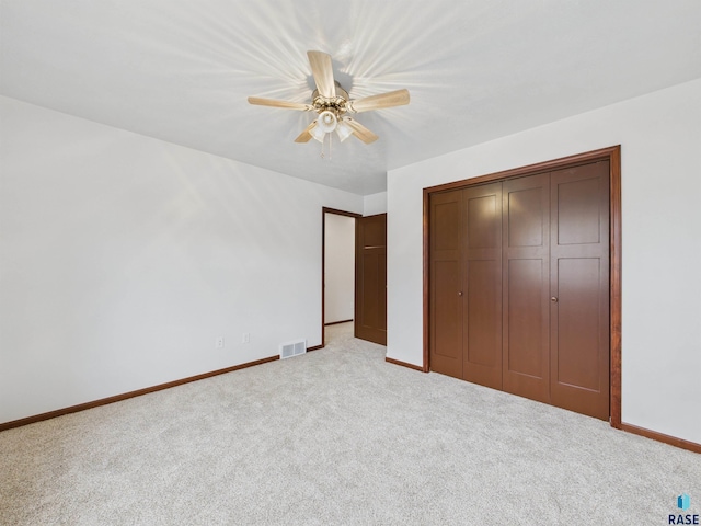 unfurnished bedroom featuring light carpet, baseboards, a closet, and visible vents