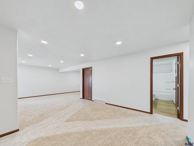 spare room featuring recessed lighting, light carpet, baseboards, and visible vents