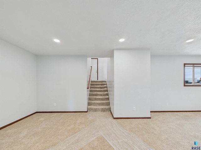 basement featuring baseboards, stairs, carpet floors, and recessed lighting