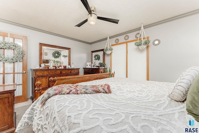 carpeted bedroom featuring a ceiling fan, crown molding, a closet, and a textured ceiling