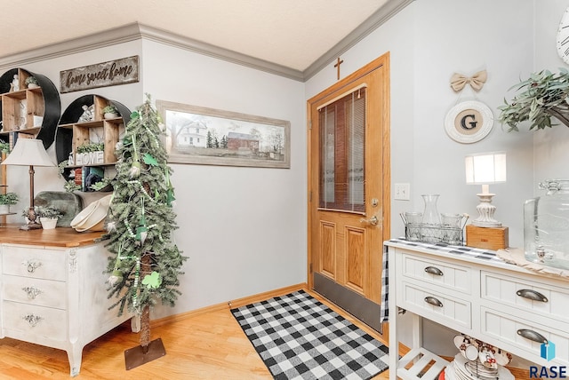 entrance foyer featuring baseboards, an AC wall unit, light wood-style floors, and crown molding