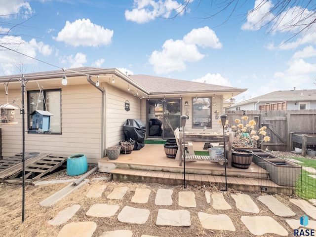 rear view of house featuring fence and a patio