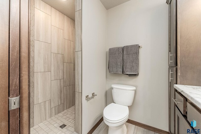 1320 Poplar Ave, Tea, SD 57064 - bathroom with tiled shower, vanity, baseboards, and toilet