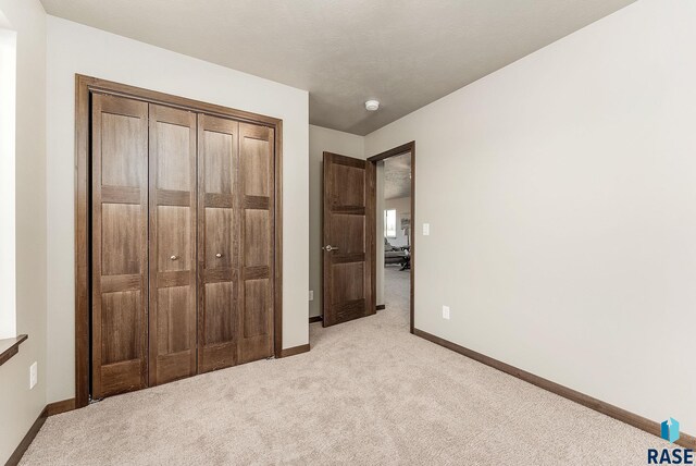 1320 Poplar Ave, Tea, SD 57064 - unfurnished bedroom featuring a closet, light colored carpet, and baseboards