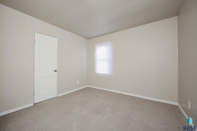 empty room with baseboards and carpet