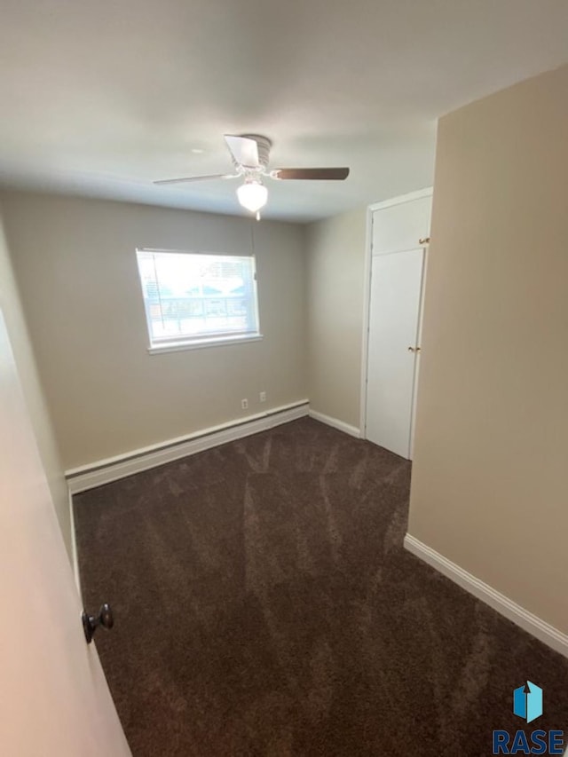 3016 E 20th St, Sioux Falls, SD 57103 - unfurnished room featuring baseboards, a ceiling fan, dark colored carpet, and baseboard heating