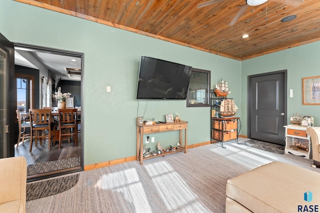 living room with baseboards, wooden ceiling, a ceiling fan, and carpet floors